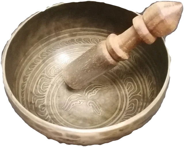 An engraved brass singing bowl with a wooden striker resting in it